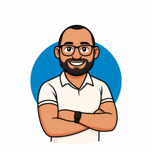 Cartoon character of a man with glasses, a beard, and a white shirt, standing with arms crossed against a blue background.